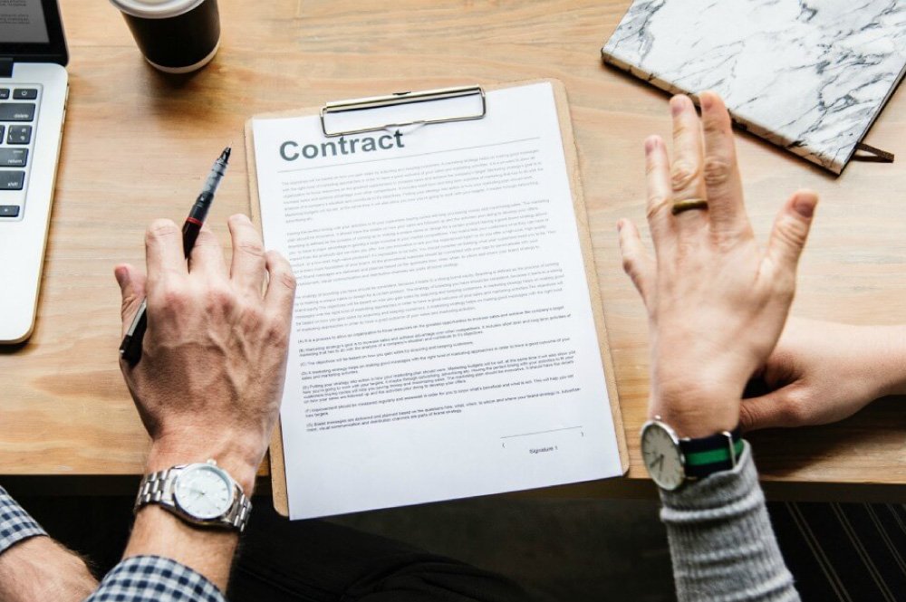 close-up of male and female about to sign a contract
