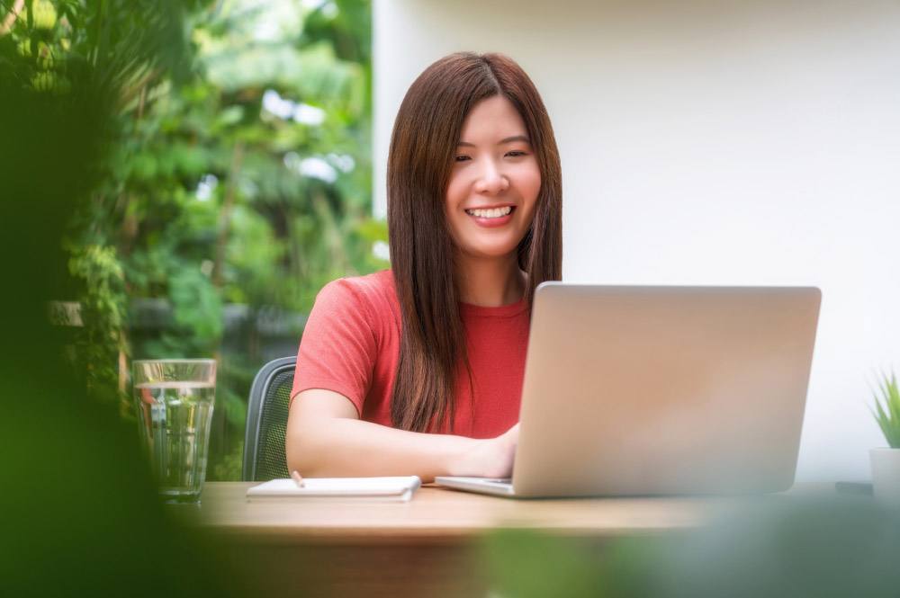 Asian woman using technology laptop for video call with boyfriend
