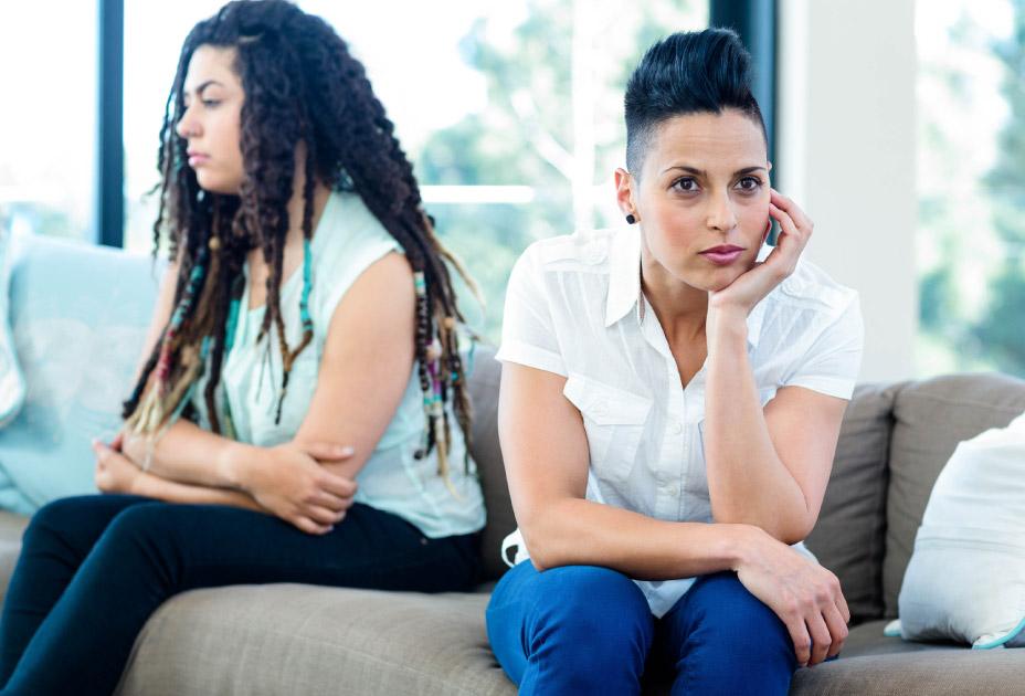 young Hispanic lesbian couple arguing on sofa