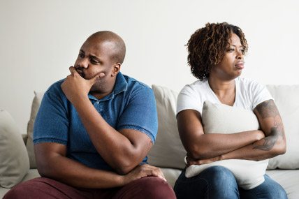 middle-aged black couple angry with each other on sofa