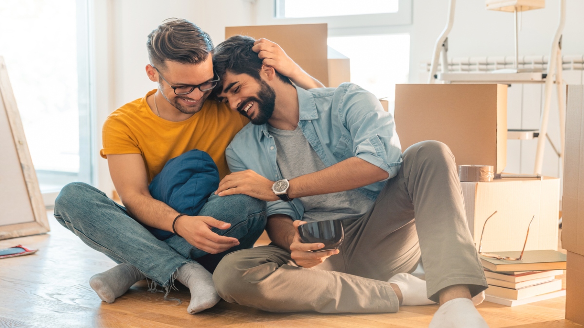 Two people sitting on the ground, embracing
